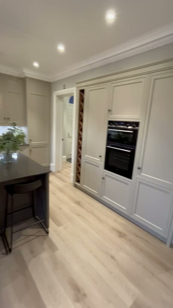 Cream shaker kitchen with tall larder units, built-in double oven and wine rack